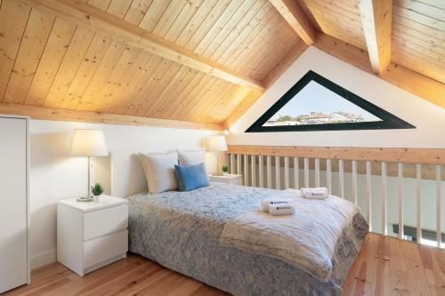 a bedroom with a bed and a wooden ceiling at Host Wise - Lovely & Cozy Duplex Flat in Porto