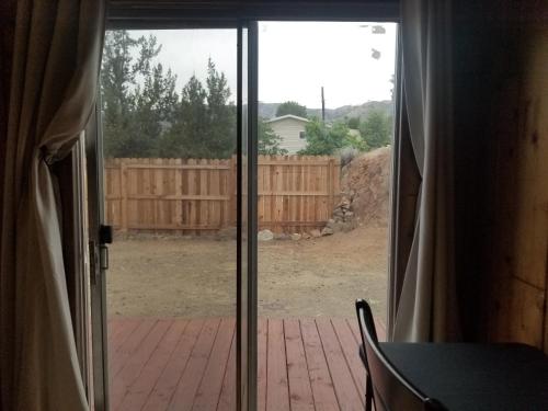 an open sliding glass door to a yard with a fence at 3BR Panoramic Lake View, Sequoia Forest, Kern County in Wofford Heights