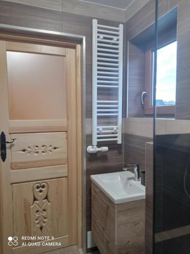 a bathroom with a toilet and a sink and a shower at Domki ,,Goramiba'' in Jurgów