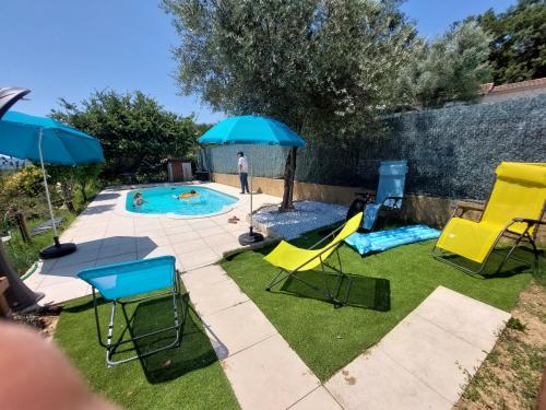 une cour avec une piscine bordée de chaises et de parasols dans l'établissement Gites Pleine Nature Belledonne, à Saint-Martin-dʼArdèche