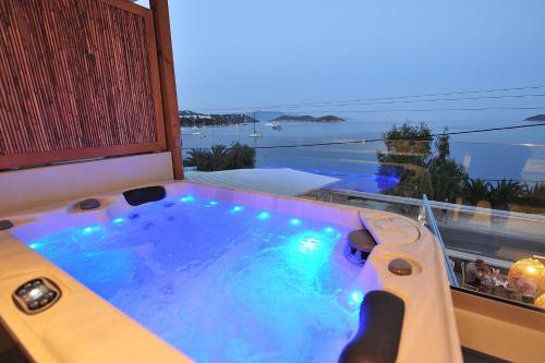 a hot tub in a balcony with a view of the ocean at Salty Wave Suites in Skiathos Town