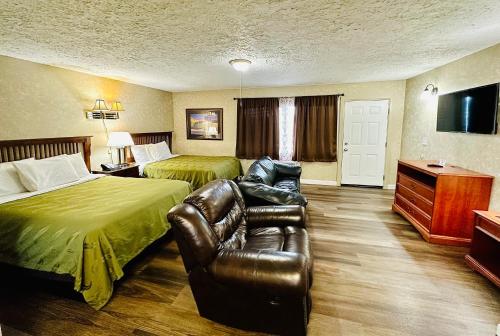 um quarto de hotel com duas camas e um sofá em Sage N Sand Motel em Moses Lake