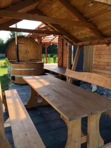 einen hölzernen Picknicktisch in einem Pavillon mit einem Fass in der Unterkunft Domek na roztoczu in Tomaszów Lubelski