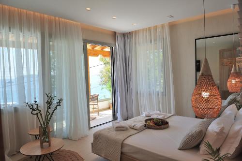 a bedroom with a bed and a large window at Salty Wave Suites in Skiathos Town