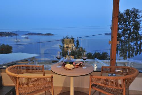 a table with two chairs and two glasses of wine at Salty Wave Suites in Skiathos Town