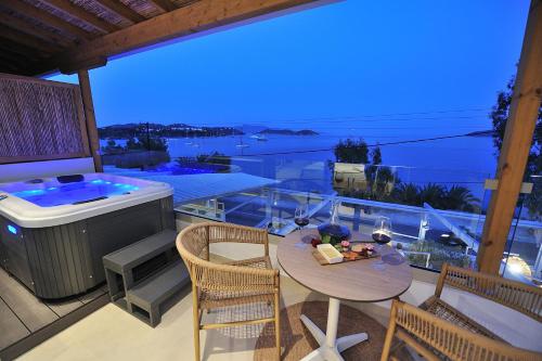 a balcony with a tub and a table and chairs at Salty Wave Suites in Skiathos Town