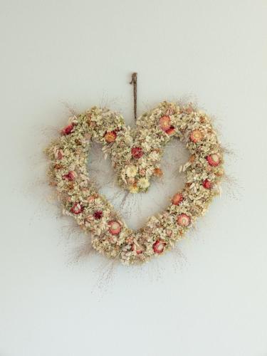 a heart shaped wreath with flowers on a wall at Dianthus Apartment in Lana