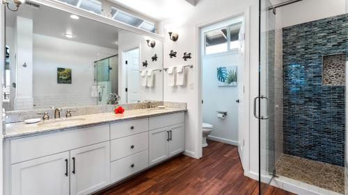 een badkamer met twee wastafels en een douche bij Mauna Lani Fairways 1601 in Waikoloa