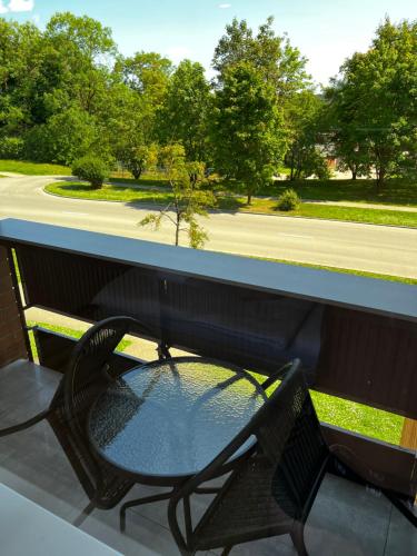 a table and chair on a porch with a street at A place to take a rest. in Tukums