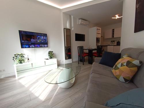 ein Wohnzimmer mit einem Sofa und einem Glastisch in der Unterkunft Foras Urban Living à 2 pas du festival in Cannes