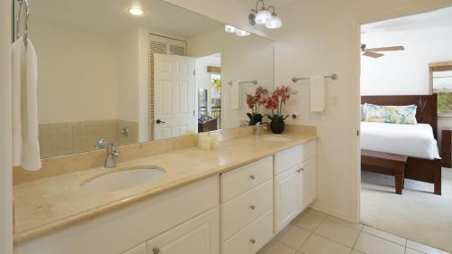a bathroom with a sink and a bedroom with a bed at Waikoloa Colony Villas 1702 in Waikoloa