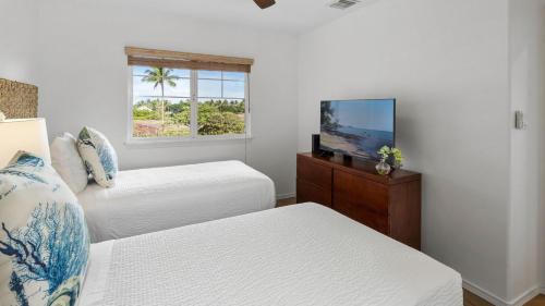 a white bedroom with two beds and a window at Waikoloa Colony Villas 1702 in Waikoloa