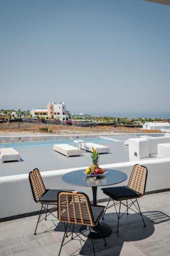 a patio with a table and chairs on a roof at Bonsai Luxury Suites in Karterados