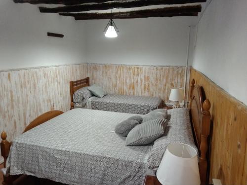 a bedroom with two twin beds and a lamp at Casa de pueblo García Marquez in Geldo