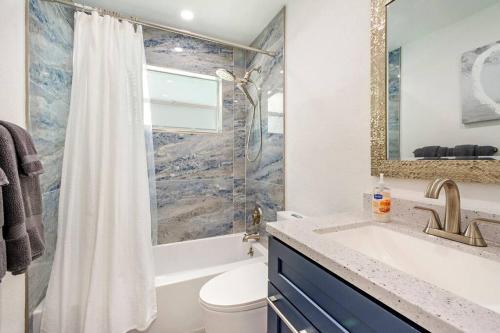 a bathroom with a sink and a tub and a toilet at Sun-Kissed Bliss: Dreamy Getaway in West Palm Beach