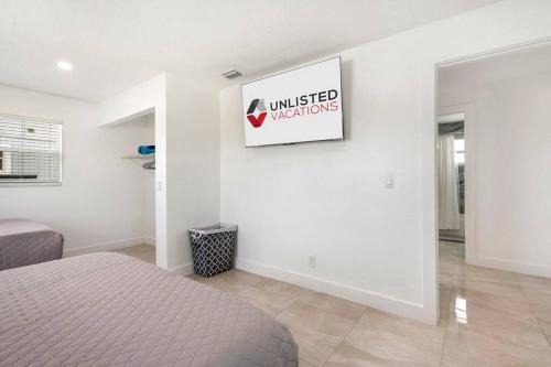 a bedroom with a bed and a sign on the wall at Sun-Kissed Bliss: Dreamy Getaway in West Palm Beach