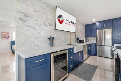 a kitchen with blue cabinets and a stainless steel refrigerator at Sun-Kissed Bliss: Dreamy Getaway in West Palm Beach