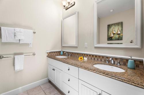 a bathroom with two sinks and a large mirror at Kulalani at Mauna Lani 205 in Waikoloa