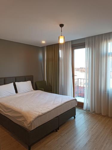a bedroom with a bed and a large window at Ore Pera Suites in Istanbul