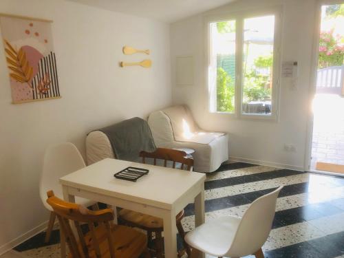 uma sala de estar com uma mesa e cadeiras e um sofá em Maisonnette climatisée refaite à neuf avec parking à 300m de la plage em Le Grau-dʼAgde