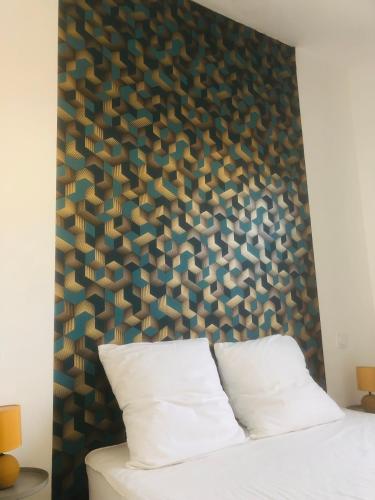 une chambre avec une grande tête de lit et un lit blanc dans l'établissement Maisonnette climatisée refaite à neuf avec parking à 300m de la plage, au Grau-dʼAgde