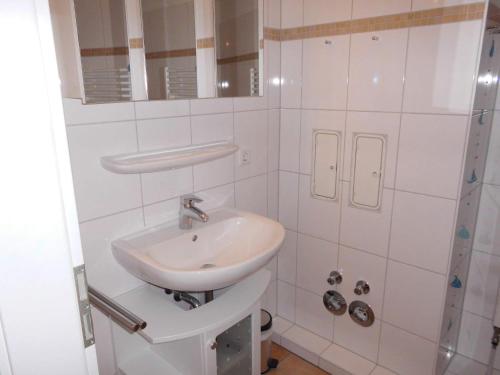 a white bathroom with a sink and a shower at DUeNENHOF-10 in Olsdorf