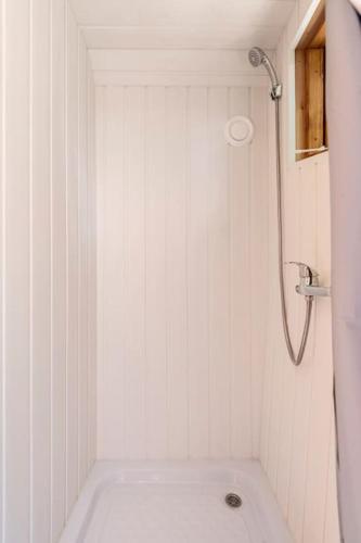 a white bathroom with a tub and a shower at Au pied du frêne in Herzeele