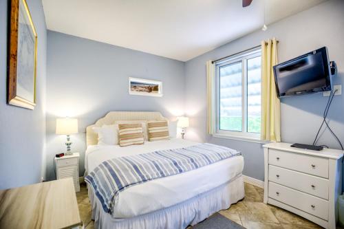 a bedroom with a bed and a tv and a window at Florida Keys Wellness Gem in Marathon