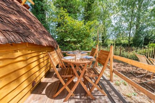 a wooden table and chairs on a wooden deck at Au pied du frêne in Herzeele