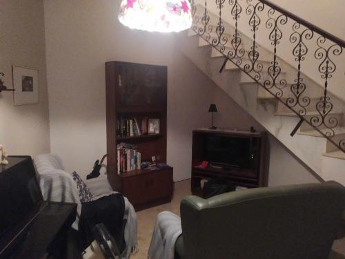 sala de estar con escalera, sofá y TV en Meadow Sweet, en San Ġwann