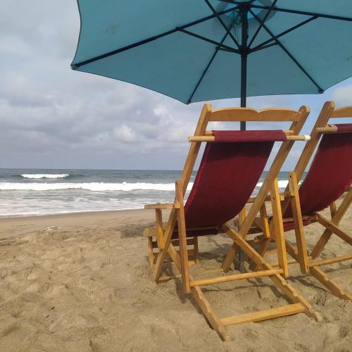 two chairs and an umbrella on the beach at MARIBAO in Playas