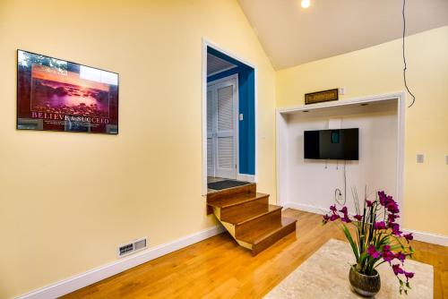 a living room with stairs and a tv at Massachusetts Vacation Rental 5 Mi to Fall River in Somerset