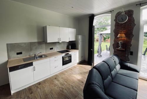 ein Wohnzimmer mit einem Sofa und einer Küche in der Unterkunft Haus Rungholt in Emmelsbüll-Horsbüll