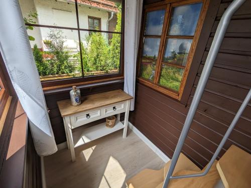 una pequeña mesa en un porche con ventana en Ferienhaus Tinyhouse21 Wasserkuppe en Gersfeld