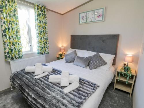 a bedroom with a large bed with white sheets and pillows at Jean's Place in Ganton