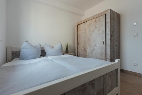 a bedroom with a large bed with a wooden headboard at Exklusive Ferienwohnungen an der Havel in Werder