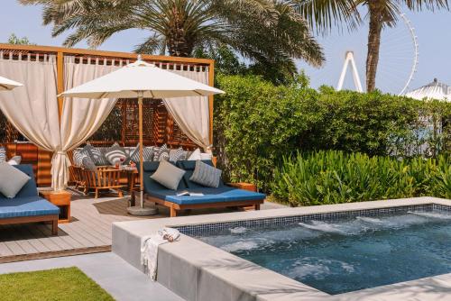 einen Pool mit 2 Stühlen und einem Sonnenschirm in der Unterkunft Sonder at JBR The Walk in Dubai