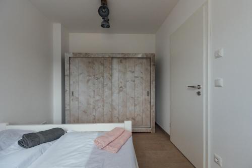 a bedroom with a bed and a wooden door at Exklusive Ferienwohnungen an der Havel in Werder