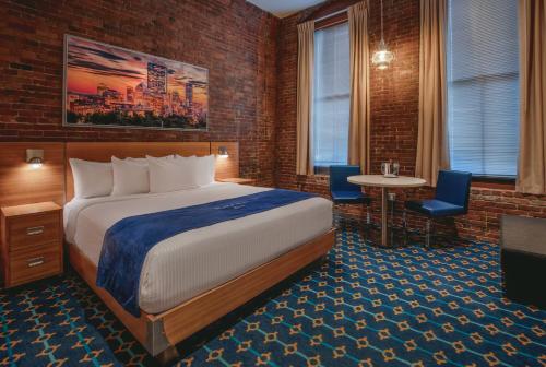 a hotel room with a bed and a table and chairs at Harborside Inn in Boston