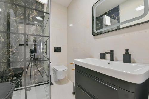 a bathroom with a sink and a glass shower at Bralic Residence in Bibinje