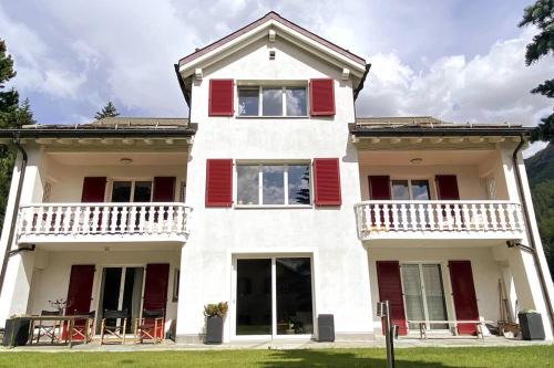 a large white house with red shutters at Chesa Giulia St.Moritz in St. Moritz