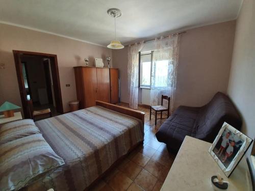 Roccascalegna的住宿－Casa dei Nonni，一间卧室配有一张床和一张沙发