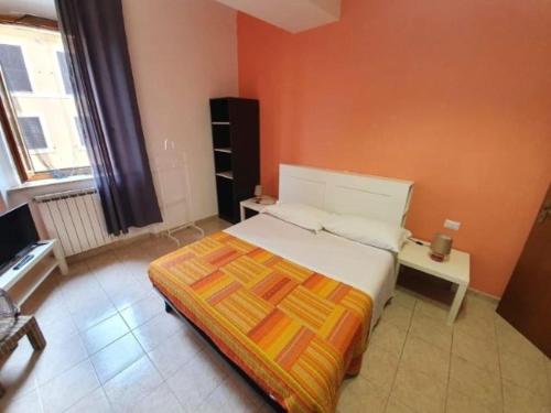una camera con un letto con una parete arancione di Le antiche mura a Civitavecchia