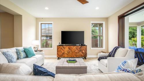a living room with two couches and a flat screen tv at Holua Kai 2 in Kailua-Kona