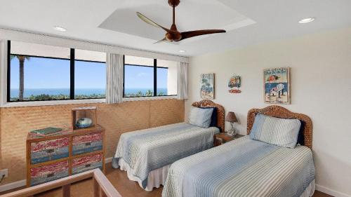 1 dormitorio con 2 camas y ventilador de techo en Country Club Villas 341, en Kailua-Kona