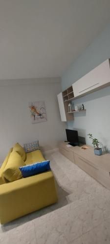 uma sala de estar com um sofá amarelo e um computador portátil em Best Residence **** em Termoli