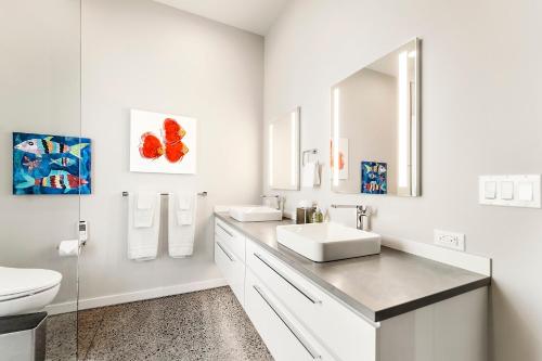 a white bathroom with two sinks and a mirror at Hapuna Modern House at Mauna Kea in Hapuna Beach