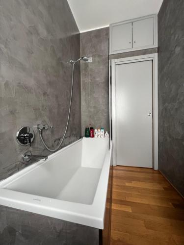 uma banheira branca na casa de banho com um chuveiro em Appartamento nel cuore di Porta Romana em Milão