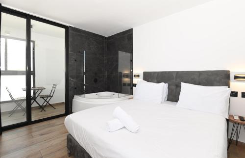 a bedroom with a large white bed and a bathroom at Selfie's Boutique Hotel in Tiberias