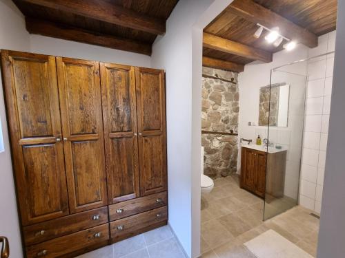 y baño con armarios de madera, aseo y ducha. en Walnut Cottage 1, en Deredzhik-Kʼoy